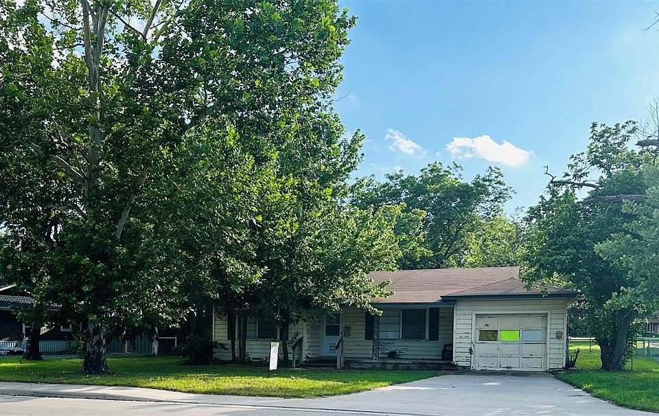 View of front of property featuring a garage and driveway