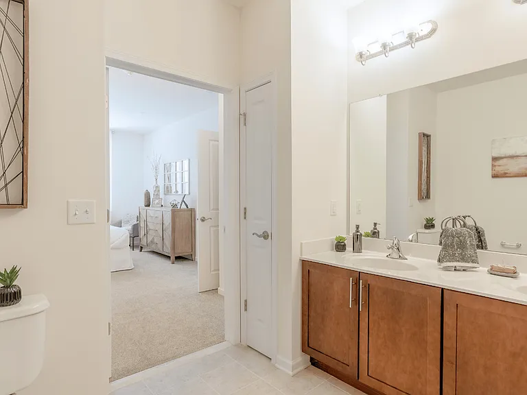 Spacious bedroom in a modern apartment featuring luxury carpeting, ample natural light, and a sleek, contemporary design for a comfortable and stylish retreat.
