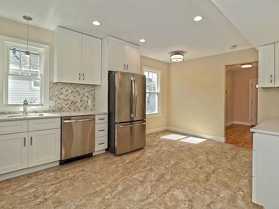 Spacious Eat -in kitchen with quartz counters, custom tile back splash, soft close cabinets