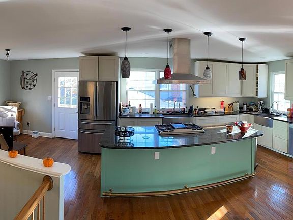 This kitchen is the center of the home! This wide-angle photo shows the upper living area. The entry foyer is on the left. The breakfast nook goes from the knee-wall, past the bay window, to the side door. The extra-large kitchen brings in loads of nat