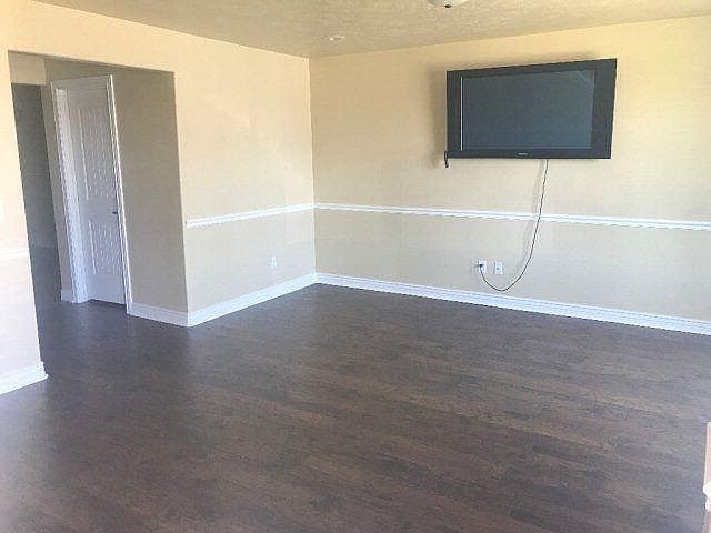 Large living room, wood floors, and flat screen T.V.