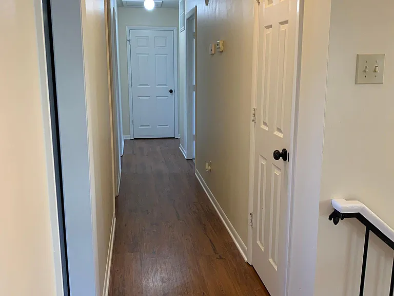 Hallway with storage closet at end & kitchen pantry