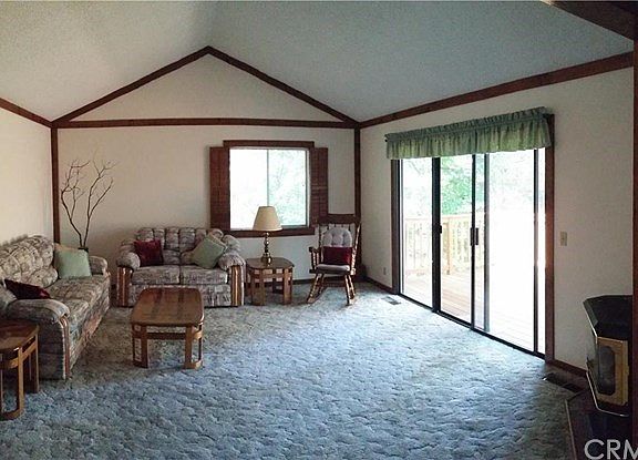 View of living room overlooking forested back yard.