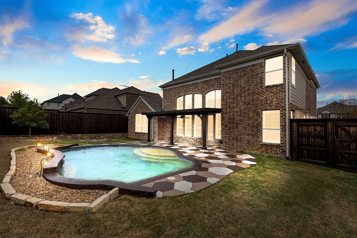 Irregularly shaped swimming pool featuring integrated steps and perimeter lighting - 8613 Vatican Dr