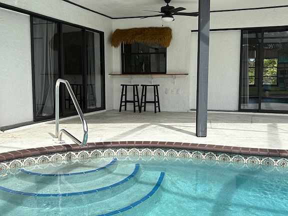 Entertain friends and family inside out! Open the back of the house with 3 sets of sliding doors that open the back of the house to the screened in pool and fun tiki bar.