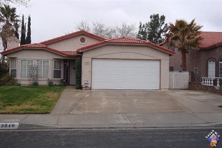 Tile roof, 2-Car Garage with extended concrete on right side.