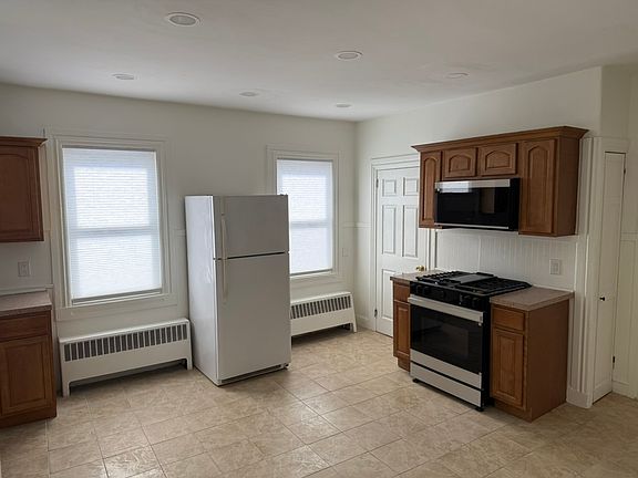 Eat-in kitchen with Samsung stove and vented microwave unit.
