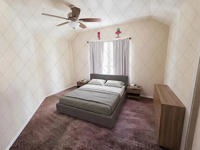 Spacious bedroom with a ceiling fan, central window with curtains, and room for a full furniture set including a dresser.