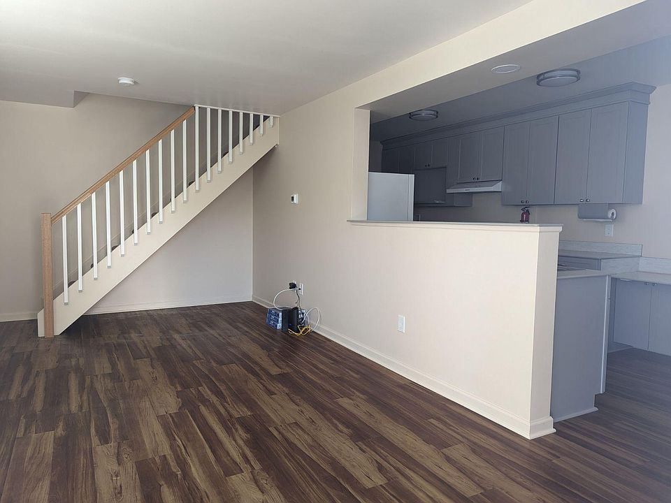 Living room with open concept to kitchen. All floors are luxury vinyl planking. Stairway is carpeted.