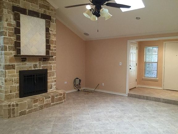 Living room with large two-sided wood-burning fireplace and skylight.