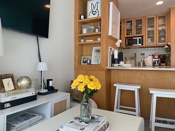 Close up of living area with wall hung flat-screen TV and bar seating for 2.