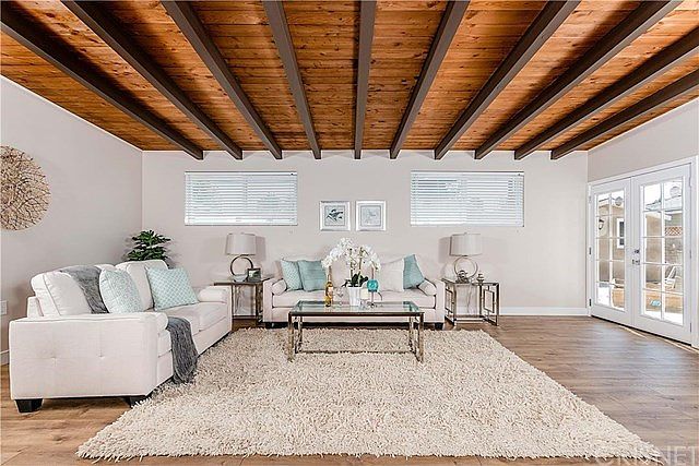 Sunken living room with wood beamed ceilings and f