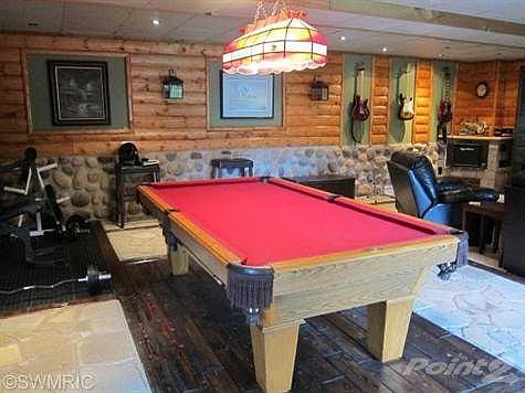 Main level family room feels like you are in a beautiful lodge. Notice natural stone flooring.