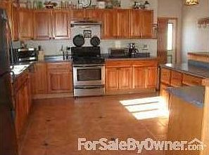 Kitchen features plenty of cherry cabinets and counter space