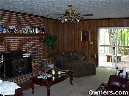 fireplace with wood stove and custom mantle piece, wood panel