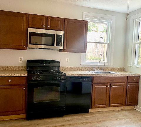 Large bright kitchen with new flooring, new microwave, and direct access to the patio