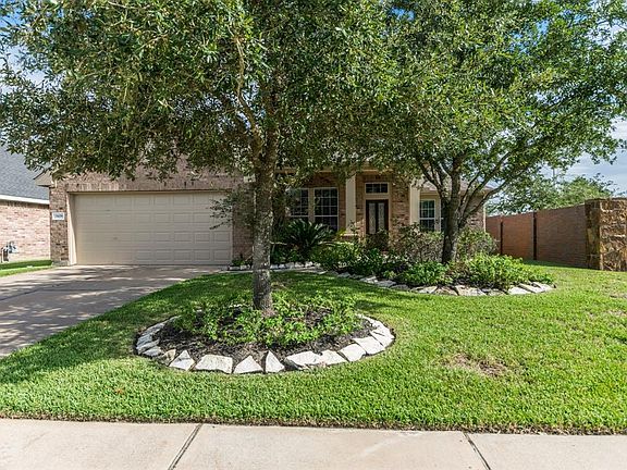 Front elevation features dual wide driveway and is surrounded by gorgeous landscaping.