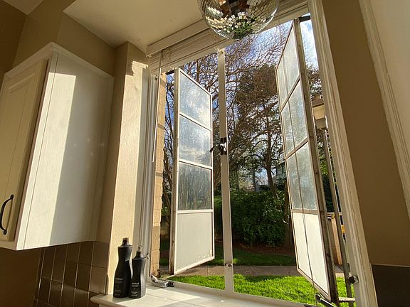 look outside to the lawn (adjacent to small parking lot) while cooking