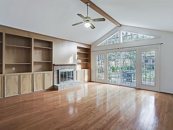 Family Room/Den. (20'x19'). Hardwood floors, beamed cathedral ceiling. Wall of French doors/windows overlook patio and enclosed portion of the back yard. Wall of built-in cabinets & shelves on either side of the fireplace (mock). Ceiling fan &