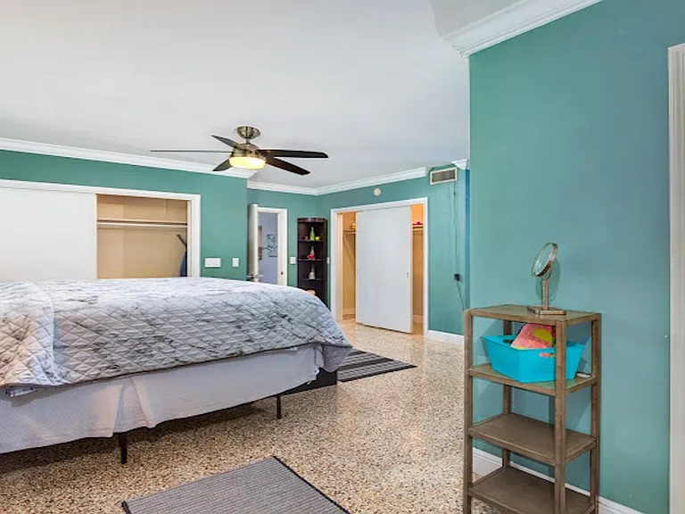 Spacious bedroom with ceiling fan, large closets, and an ensuite bath for convenient daily routines.