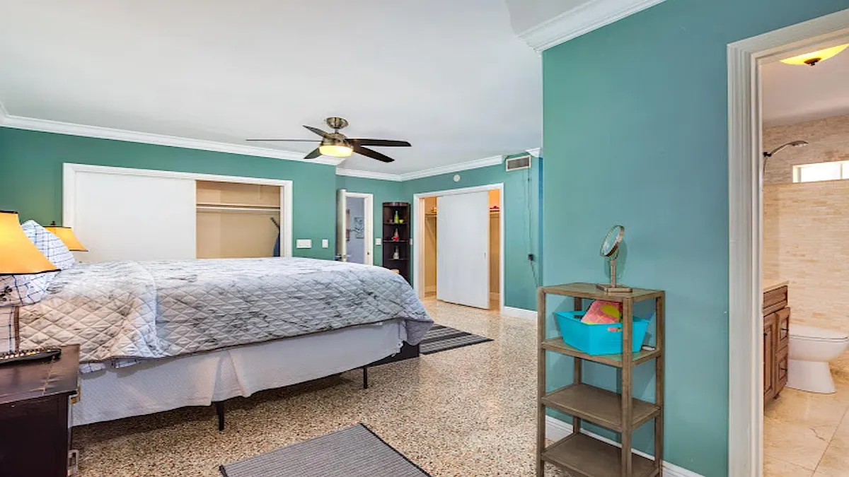 Spacious bedroom with ceiling fan, large closets, and an ensuite bath for convenient daily routines. - SE 3rd Ave
