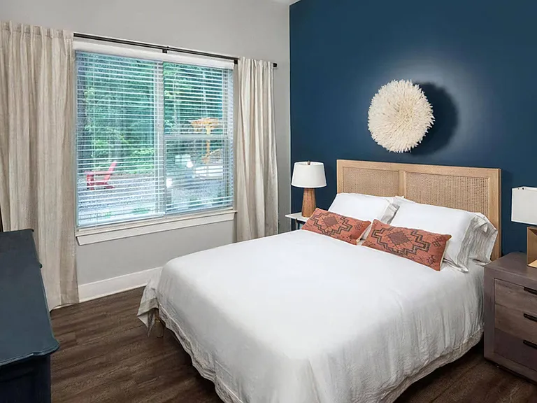 Stylish Bedroom Featuring Natural Light, Textured Decor, and Wood-Style Flooring