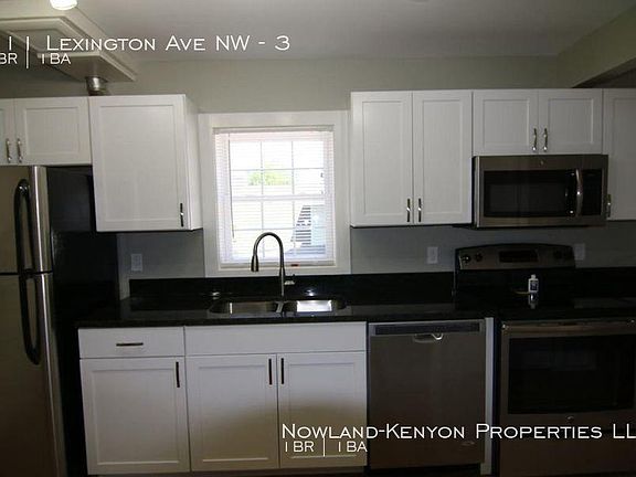 More of the kitchen has a refrigerator, dishwasher, microwave and stove. Photo taken from the eating area in the kitchen.