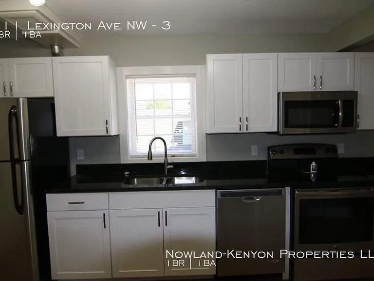 More of the kitchen has a refrigerator, dishwasher, microwave and stove. Photo taken from the eating area in the kitchen.