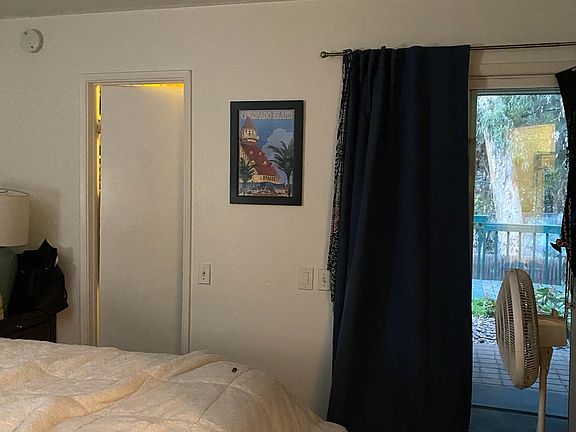 Primary bedroom (with furniture) - walk in closet to the left, patio door to the right