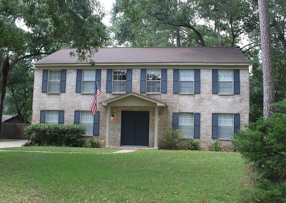 Lovely hardwood trees shade the lawn of this traditional home.