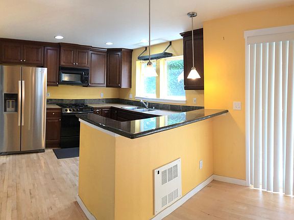 open concept kitchen & dining area with granite breakfast nook and balcony
