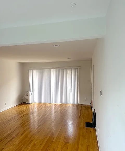 Living room view from dining area to front sliding doors and entryway.