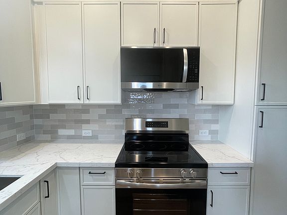 Stainless 30" Electric range/oven with microwave range/hood combonation, full height tile backsplash with solid quartz countertops