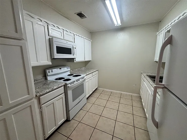 Carpeted room with multiple paneled doors and a closet featuring a hanging rod