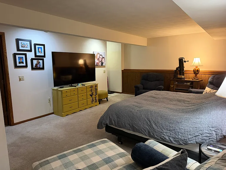 Lower level family room with current tenants furniture. Being used as a bedroom at this time.