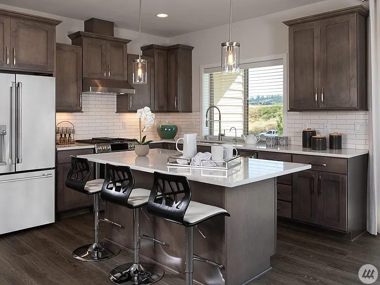 Bright, modern kitchen featuring quartz countertops, stainless steel appliances, abundant cabinetry, and a spacious island with seating - perfect for everyday dining and entertaining.