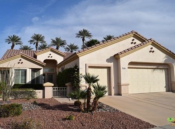 Front of home with gold cart parking