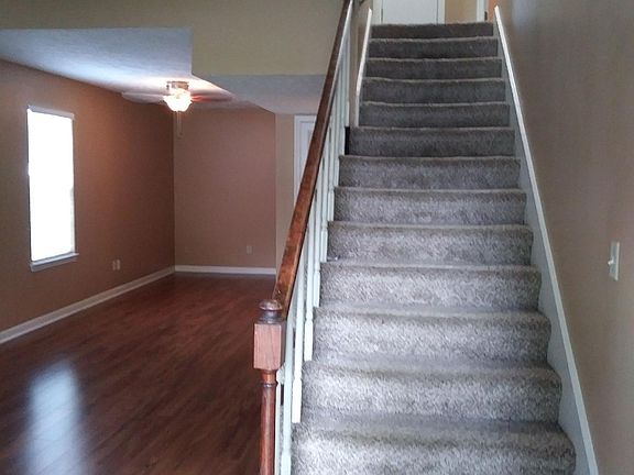 Two-story entrance & living room with laminate wood flooring