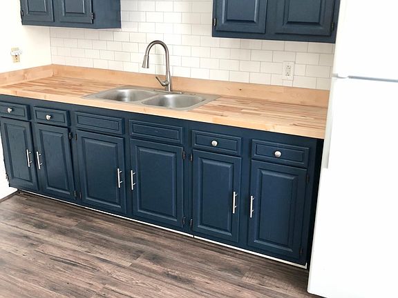 Kitchen with new butcher block countertops - refrigerator and range/oven.