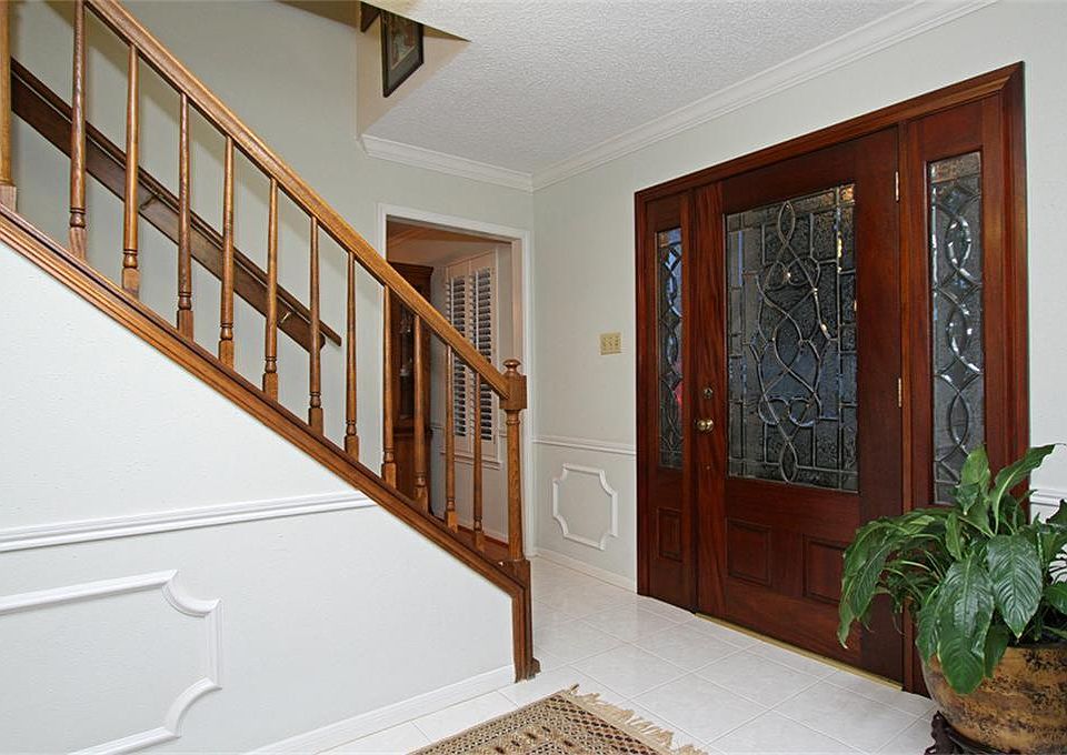 Double leaded glass mahogany front doors welcome guests. Foyer with marble floors flanked by a formal dining on right and formal living room on left.