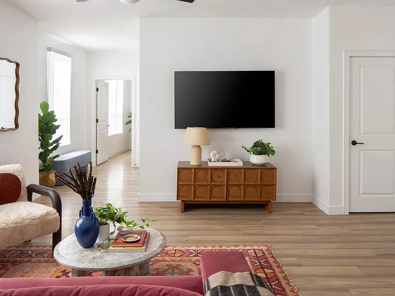 Clean lines, warm wood accents, and natural light create a living space that feels open, inviting, and effortlessly styled.