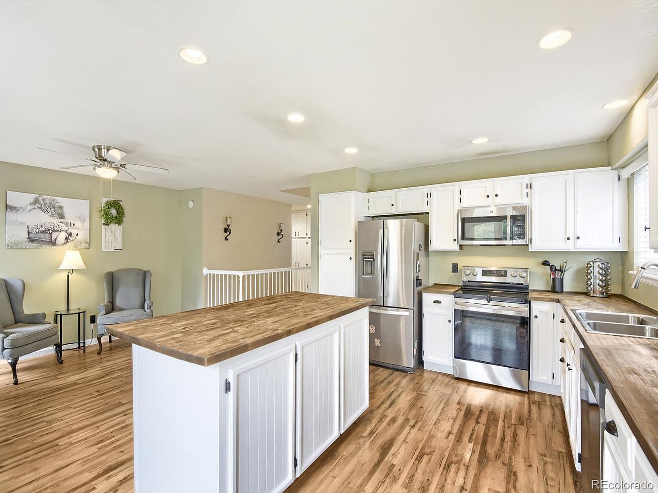 Bright kitchen with butcher-block island and white cabinetry