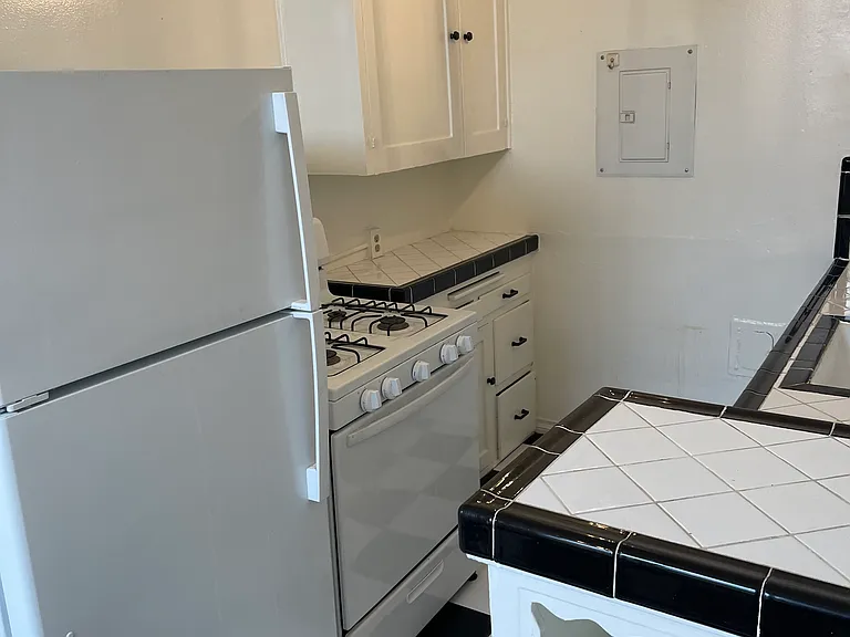Kitchen has cute vintage features but modern lighting and hardware and newer tile floors