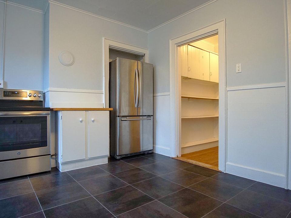 Looking into the kitchen from the back stairwell door. Kitchen has almost new appliances and brand new floor! To the right is the butler's pantry with tons of storage.