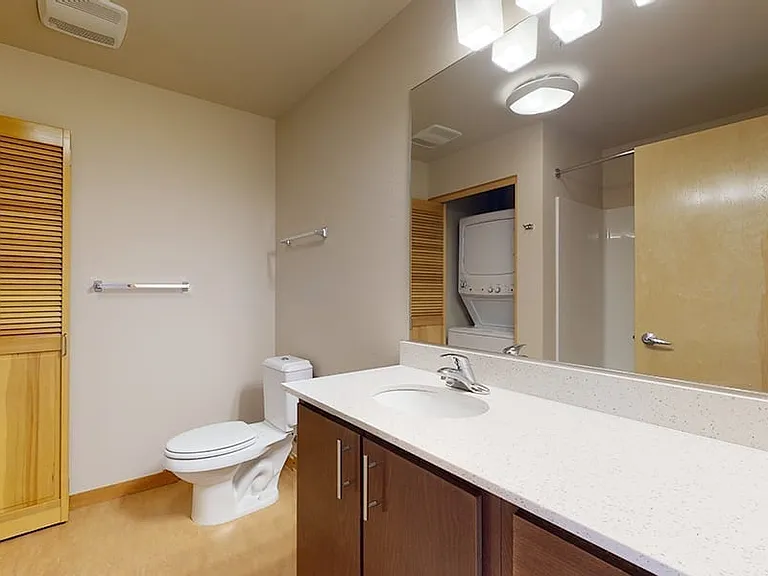 Apartment Bathroom with large soaking tub and Wood-Style Flooring.