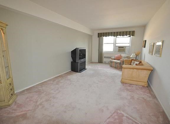 Large living room with covered hardwood floors.