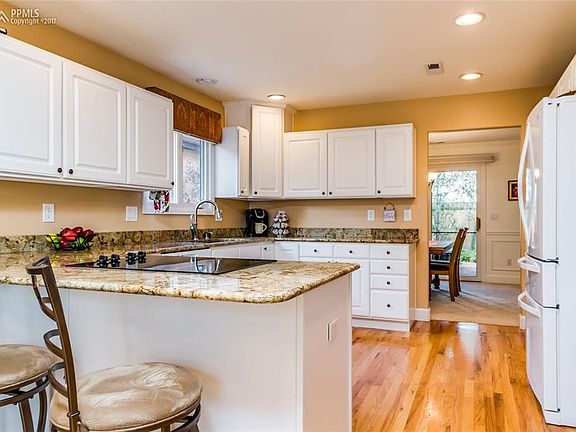 Gorgeous kitchen with a breakfast bar, granite slab counter, lots of storage and