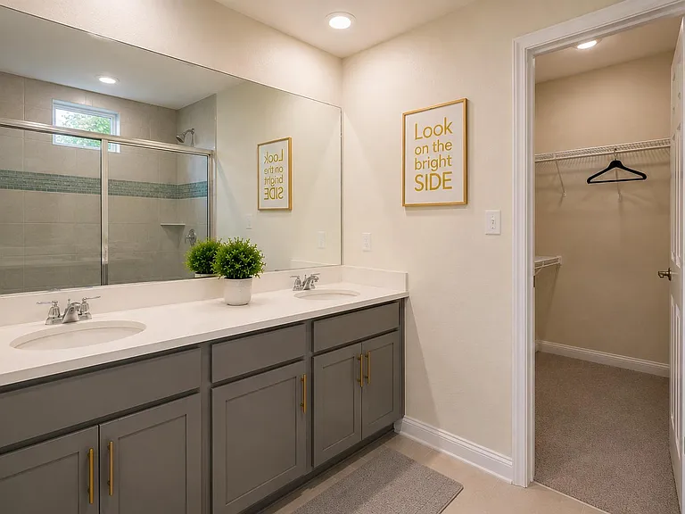 Bathroom features a double-sink vanity with a large mirror, plus a tiled shower and adjacent walk-in closet for storage.