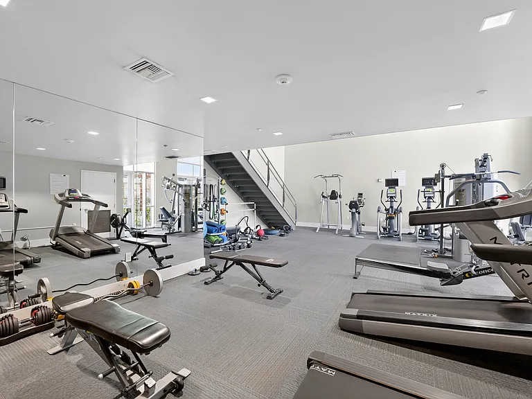 Fitness center with cardio machines, strength equipment, free weights, mats, kettlebells, BOSU ball, yoga balls, jump ropes and open workout space.
