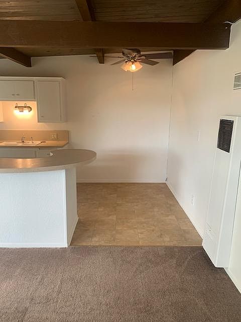 Dining area adjacent to kitchen with ceiling fan.
